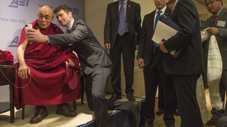 Blogger Alek Boyd takes a selfie with the Dalai Lama at the American Enterprise Institute in Washington during a break between panel discussions on "Happiness, Free Enterprise, and Human Flourishing" on February 20, 2014.