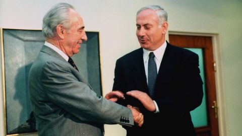 Netanyahu shakes hands with outgoing Israeli Prime Minister Shimon Peres before taking the office himself in June 1996.