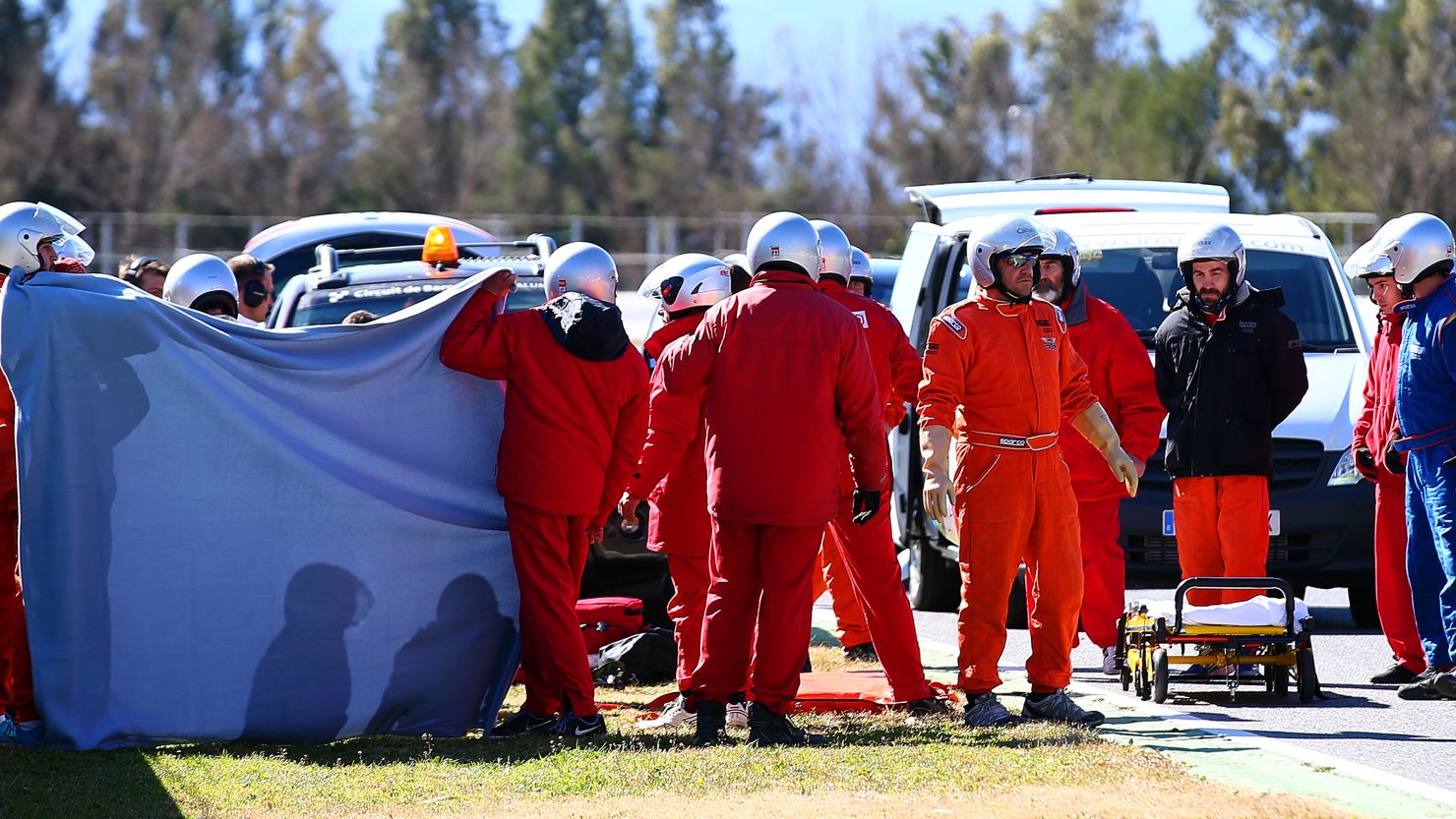 A screen is put up around Fernando Alonso's car as a medical team attends to the two-time world champion after his crash in testing.
