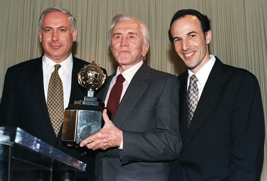 Actor Kirk Douglas holds the King David Award, presented to him by the Jerusalem Fund of Aish HaTorah during a dinner in Beverly Hills, California, in November 1997. Douglas was honored for his inspirational commitment to Israel and the Jewish people and in recognition of his new book "Climbing the Mountain." On the right is Rabbi Nachum Braverman, director of the Jerusalem Fund of Aish HaTorah.