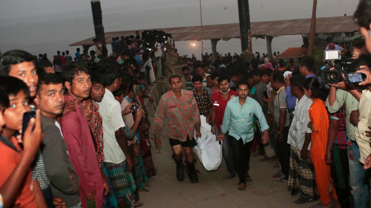 Rescue workers carry bodies after a ferry capsized after being hit by a boat on Sunday in Bangladesh.
