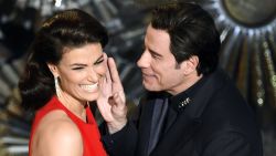 John Travolta and Idina Menzel present an award on stage together, referencing last year's flub when he mispronounced her name.