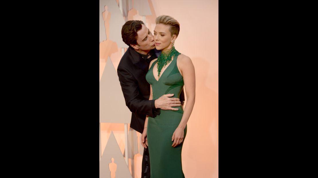 John Travolta gives Scarlett Johansson a smooch.