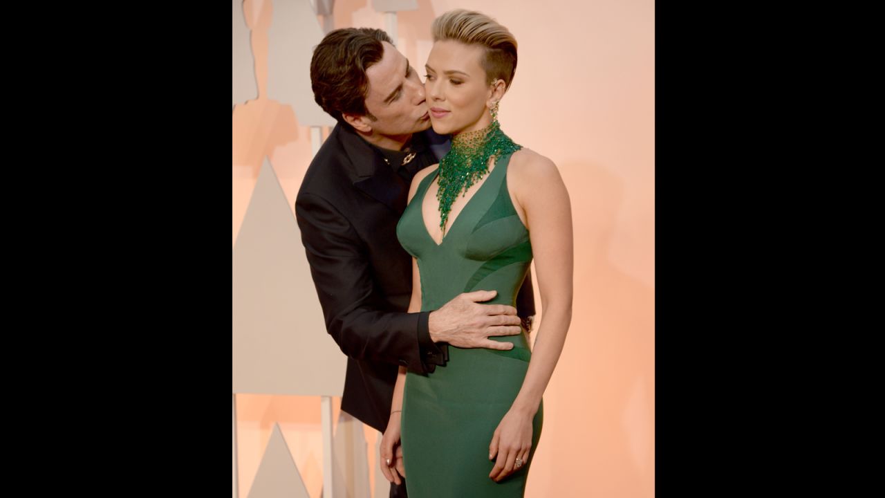 Travolta had a frisky night. Here he gives Scarlett Johansson a smooch and a squeeze on the red carpet. 