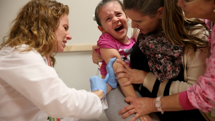 Miami Children's Hospital pediatrician Dr. Amanda Porro, M.D administers a measles vaccination to Sophie Barquin,4, as her mother Gabrielle Barquin and Miami Children's Hospital R.N. Diane Lichtman, right, hold her during a visit to the Miami Children's Hospital on January 28, 2015 in Miami, Florida. A recent outbreak of measles has some doctors encouraging vaccination as the best way to prevent measles and its spread.