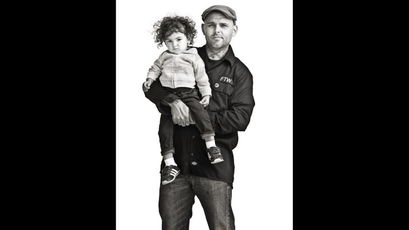 Shaun, a motorcycle tech shop owner in Texas, poses with his daughter.