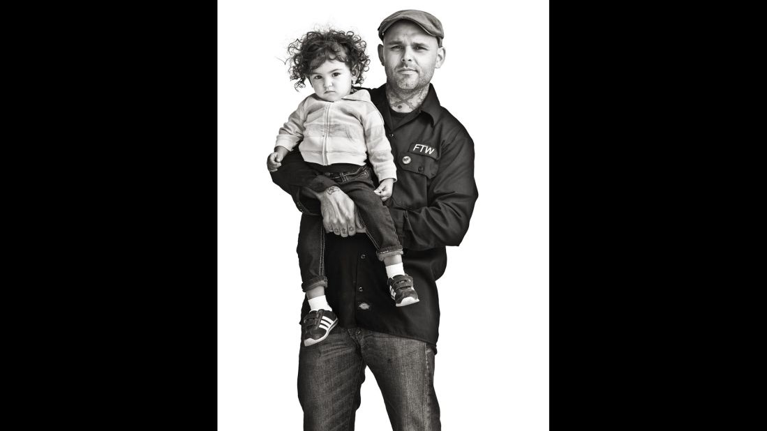 Shaun, a motorcycle tech shop owner in Texas, poses with his daughter.
