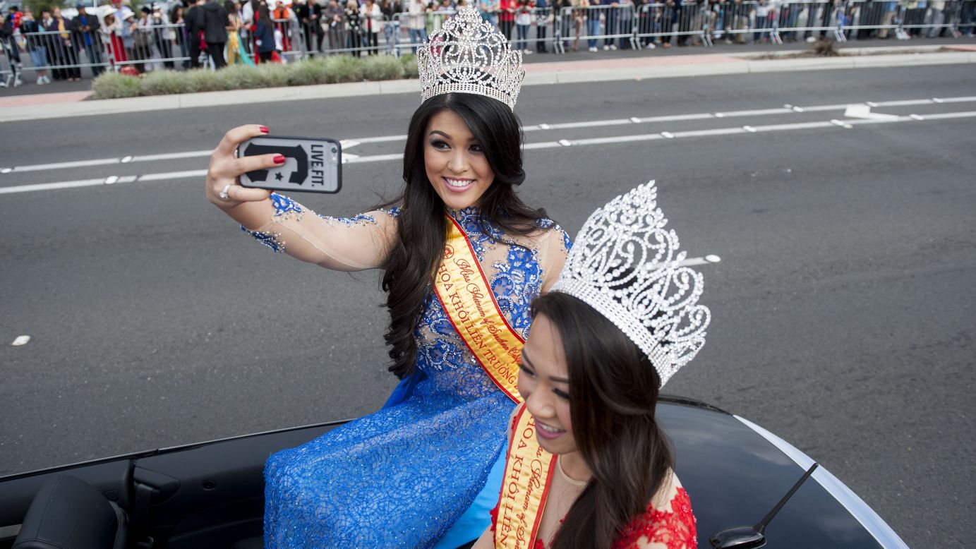 Anne Phung Nguyen, the 2014 Miss Vietnam of Southern California, takes a selfie next to her successor, Diem Nguyen, as the annual Tet Parade kicks off in Westminster, California, on Saturday, February 21.