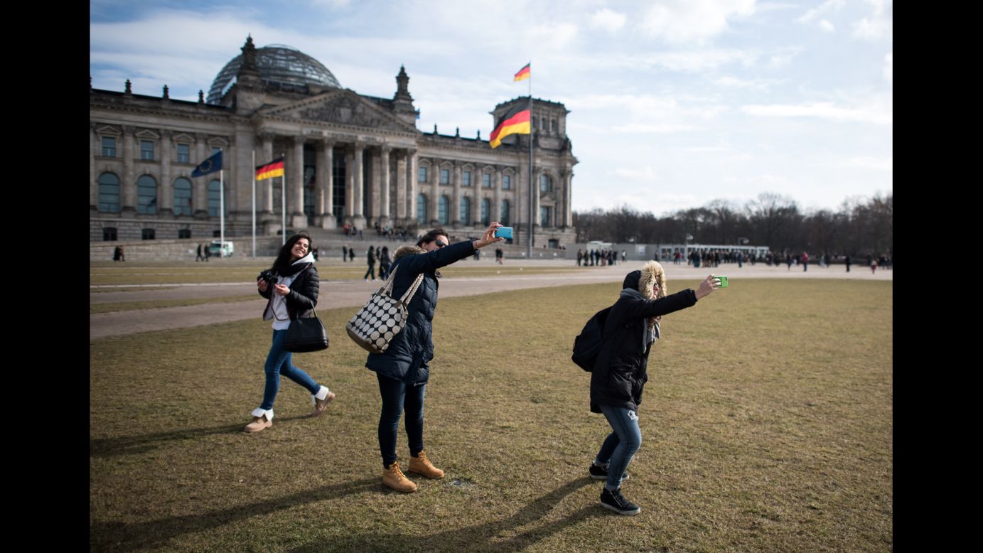 A couple of students from Italy take photos of themselves in front of the Reichstag building in Berlin on Tuesday, February 24.