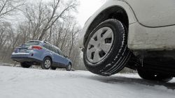 A driver moves slowly past a stranded vehicle at right that slid off of the road in Chapel Hill, N.C., Tuesday, Feb. 24, 2015, after winter weather moved through the area causing numerous accidents and slippery driving conditions. (AP Photo/Gerry Broome)