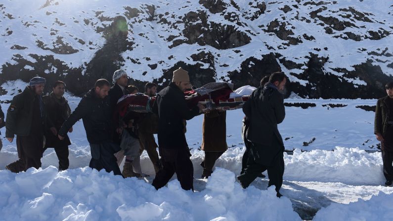 Men carry the body of an avalanche victim after funeral prayers in Khench, Afghanistan, on Thursday, February 26. 
