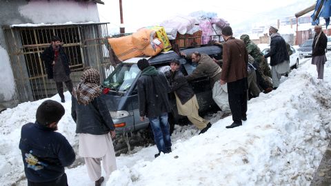 People push a car stuck near an avalanche site in Panjshir province February 25.