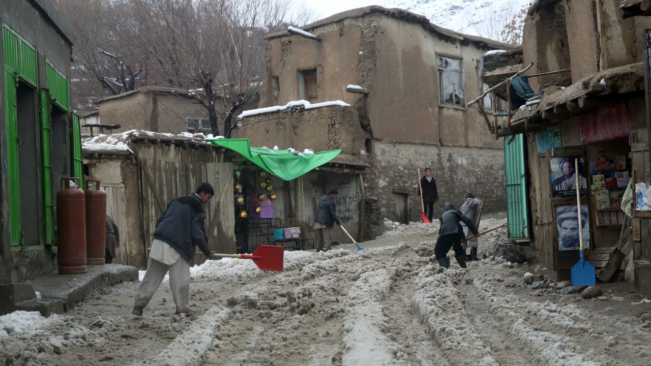 People clean snow from a road in Panjshir province February 25.