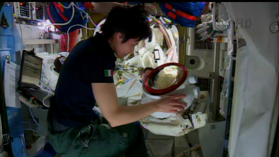 Italian astronaut Samantha Cristoforetti examines Terry Virts' helmet.