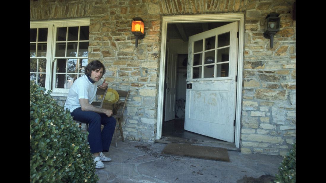 Polanski sits on the bloodied porch of his home after the bodies of his wife, Tate, and her friends were found inside in August 1969. Tate was one of five people murdered ritualistically by Charles Manson cult followers.