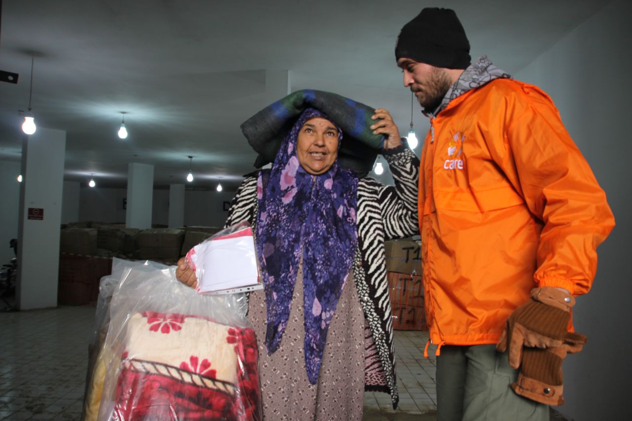 A CARE aid worker provides relief supplies for winter to a Syrian refugee in Turkey.  Many refugees struggle to find winter clothes, boots and blankets.