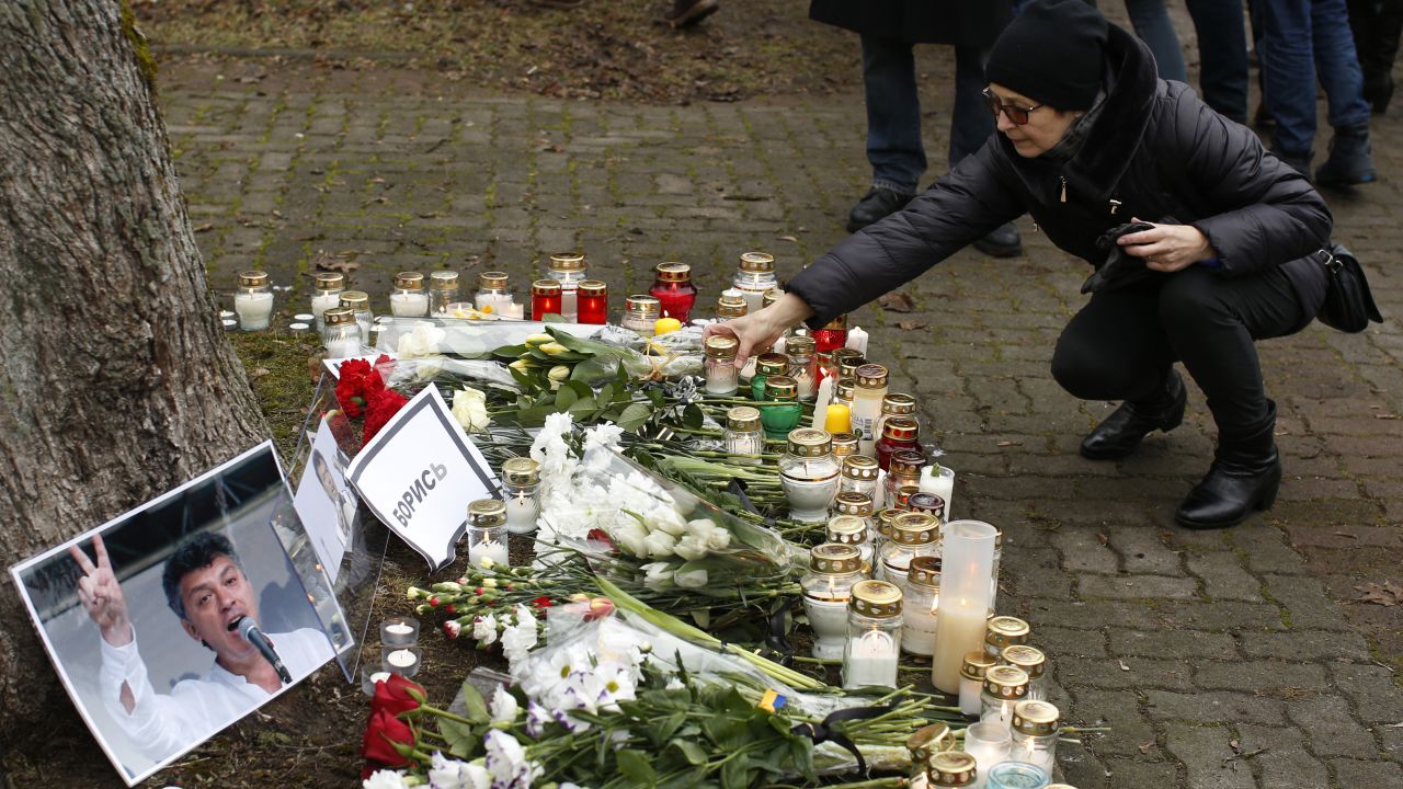 A woman places a candle at a makeshift memorial in front of the Russian Embassy in Vilnius, Lithuania, on March 1.