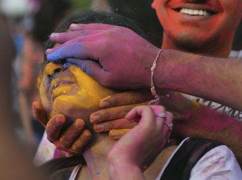 MARCH 2 - MANILA, PHILIPPINES: Revelers place colored powder on a woman's face as they celebrate the Holi festival in Pasay, south of Manila. The event is led by Indian nationals as they mark the spring occasion, also known as the festival of colors.