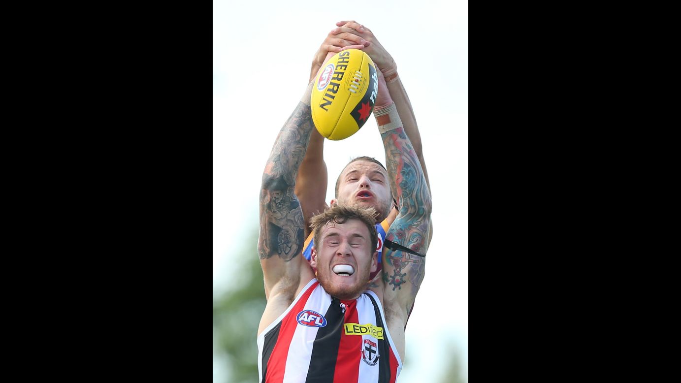 Tim Membrey of the St. Kilda Saints, front, and James Aish of the Brisbane Lions compete for the ball during an Australian Football League match on Saturday, February 28.