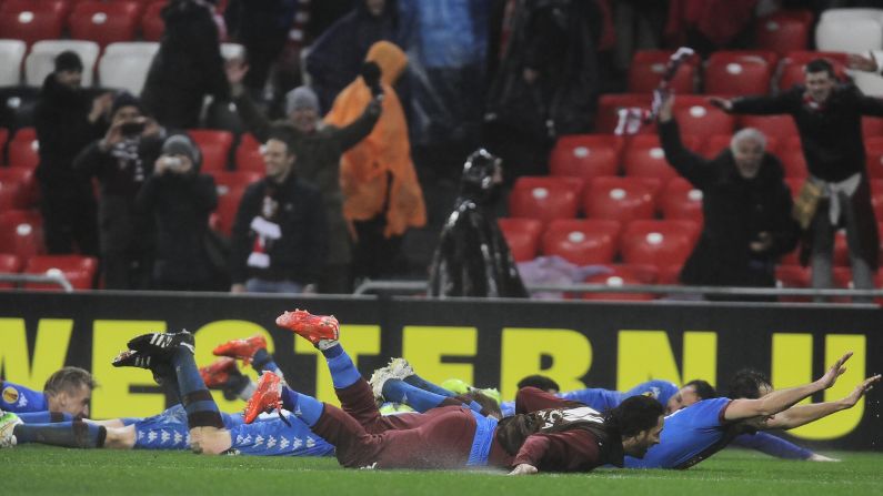 After a 3-2 victory over Athletic Bilbao, members of the Torino soccer club celebrate by sliding on the grass Thursday, February 26, in Bilbao, Spain. The victory pushed the Italian club into the Europa League's round of 16.