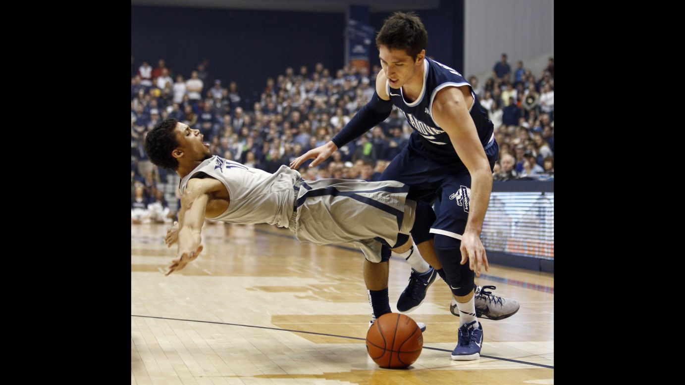 Xavier guard Dee Davis, left, draws a charge on Villanova's Ryan Arcidiacono during a college basketball game in Cincinnati on Saturday, February 28. Villanova won the game 78-66 and clinched the regular season title in the Big East Conference.