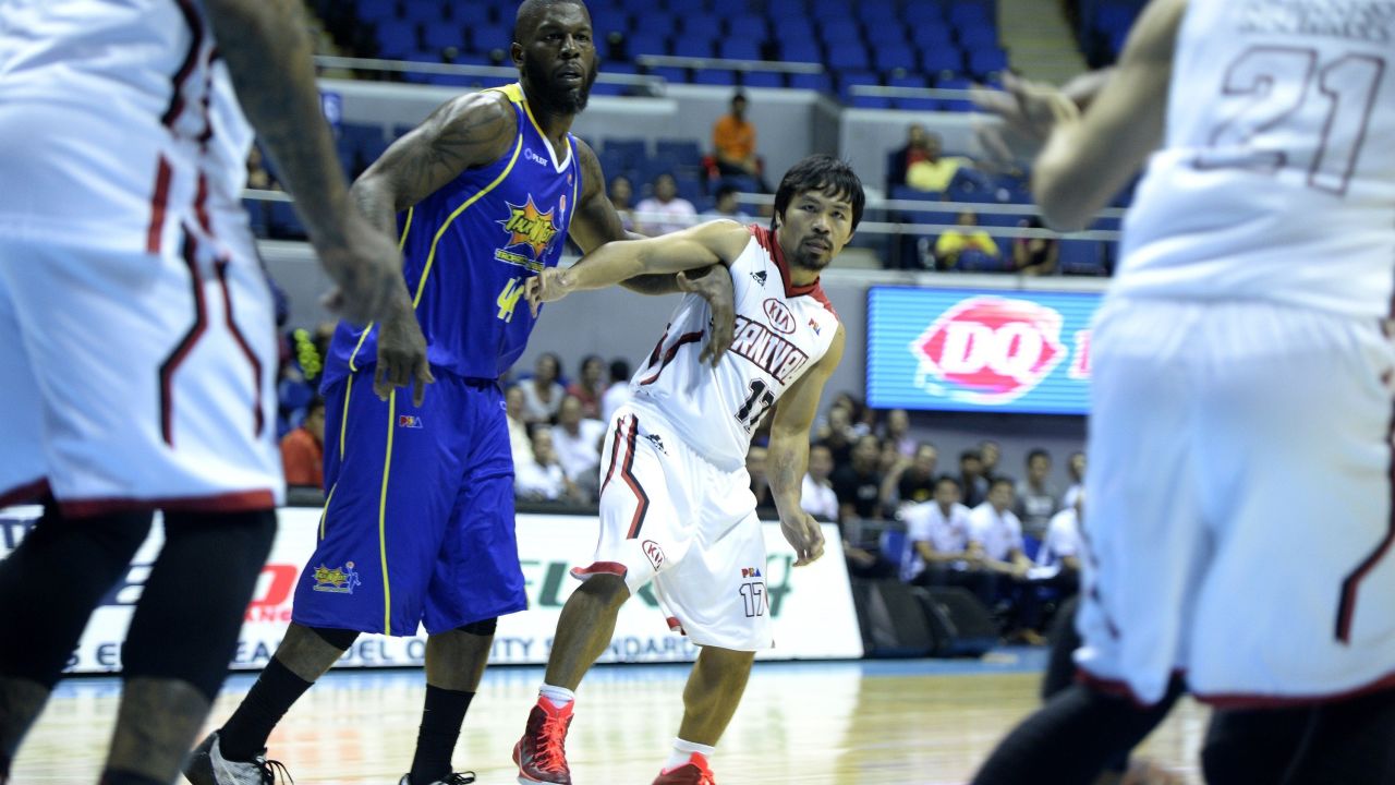 Philippine boxing hero Manny Pacquiao (centre R) of Kia is pushed by Ivcan Johnson of Talk and Text during a professional basketball game in Manila on February 25, 2015. Philippine boxing hero Manny declared himself an enemy of doping on February 25, ahead of a megabucks bout with unbeaten Floyd Mayweather, his longtime rival as the planet's best "pound-for-pound" fighter. AFP PHOTO / NOEL CELIS NOEL CELIS/AFP/Getty Images