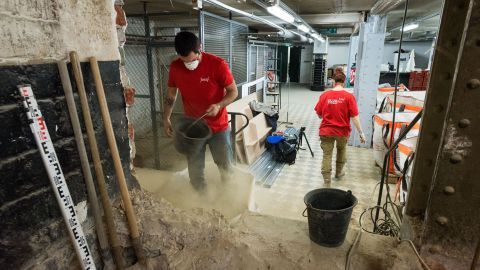 A team of archeologists sifts through dirt to unearth centuries-old skeletons under a Paris supermarket.
