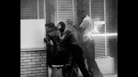Demonstrators in Birmingham, Alabama, huddle in a doorway to seek shelter as authorities try to disperse them with water hoses in 1963.