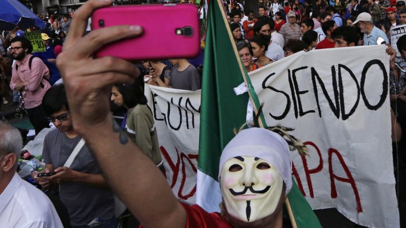 A protester wearing a Guy Fawkes mask takes a selfie Thursday, February 26, during a march in Mexico City demanding justice for the 43 college students <a href="index.php?page=&url=http%3A%2F%2Fwww.cnn.com%2F2015%2F02%2F19%2Famericas%2Fmexico-missing-students-ash-wednesday%2Findex.html" target="_blank">who went missing</a> in September.