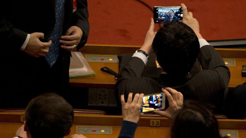 A delegate takes a selfie with his smartphone before the opening session of the Chinese People's Political Consultative Conference in Beijing on Tuesday, March 3.