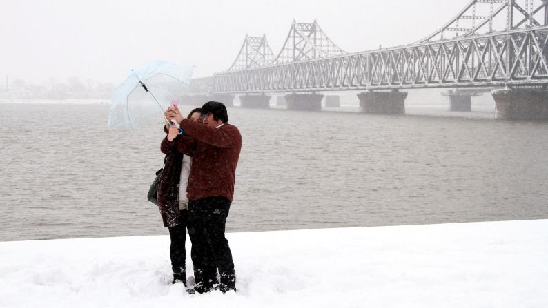People use a selfie stick by the side of the Yalu River in Dandong, China, on Wednesday, February 25.
