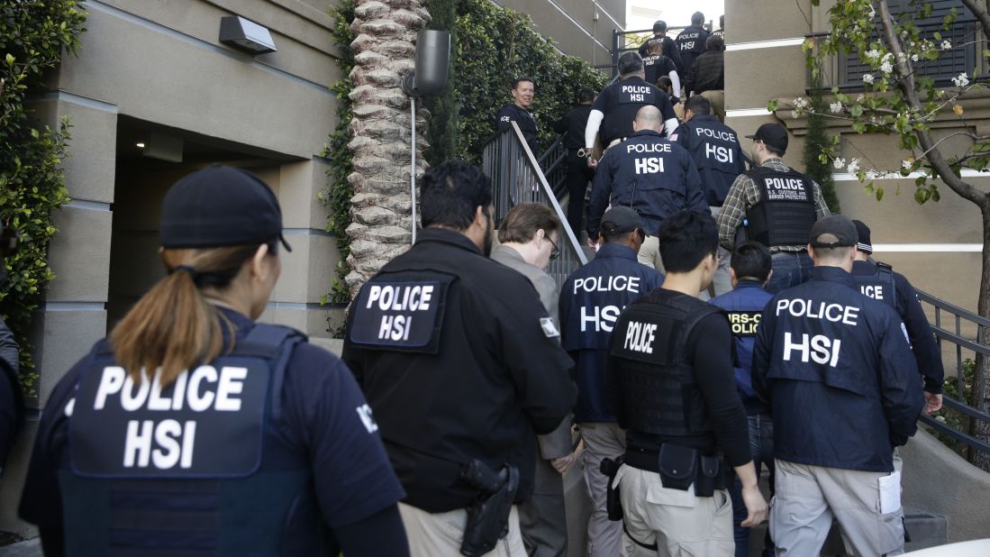 Federal agents enter an upscale apartment complex on Tuesday, March 3, in Irvine, California. More than three dozen "maternity hotels" were raided in Southern California, where foreign women give birth, allegedly for the sole purpose of having a U.S.-citizen baby, authorities said.