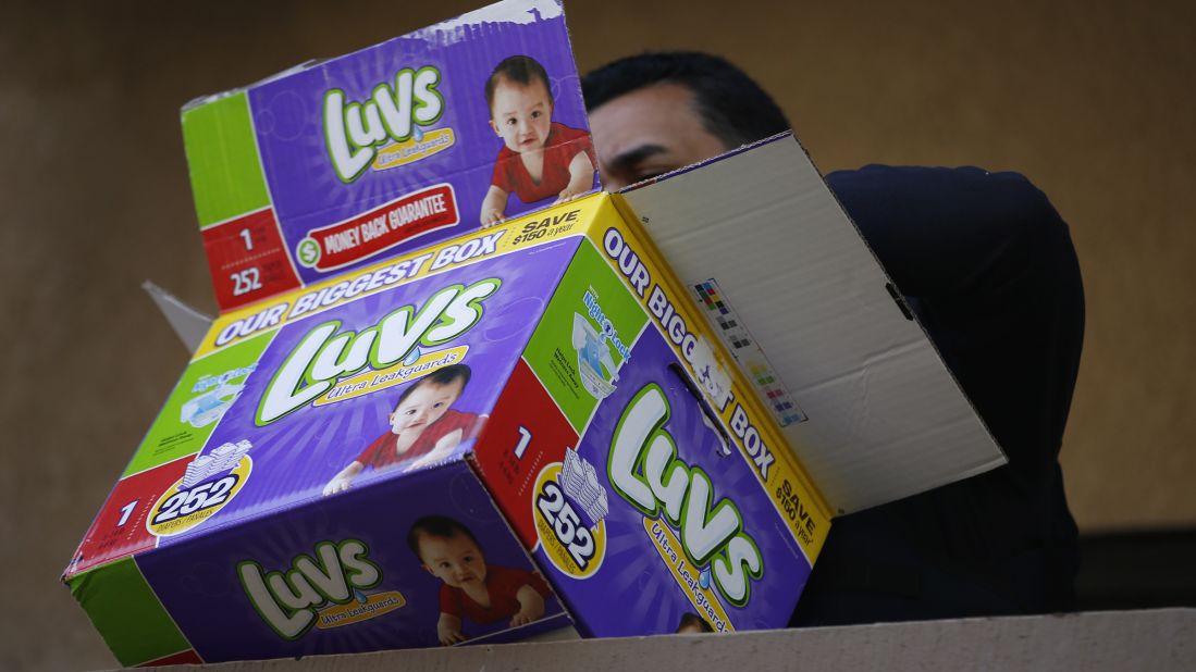 A federal agent looks through a disposable diaper box while serving warrants at an apartment complex during an ongoing investigation of alleged birth tourism centers.