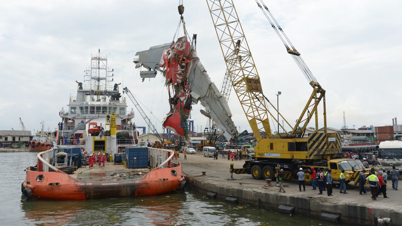 Crews remove the fuselage of AirAsia Flight QZ8501 from a vessel at the Tanjung Priok Port in Jakarta, Indonesia, on Monday, March 2. AirAsia Flight QZ8501 was en route from Surabaya, Indonesia, to Singapore when it lost contact with air traffic control on December 28. There were 162 people on board.