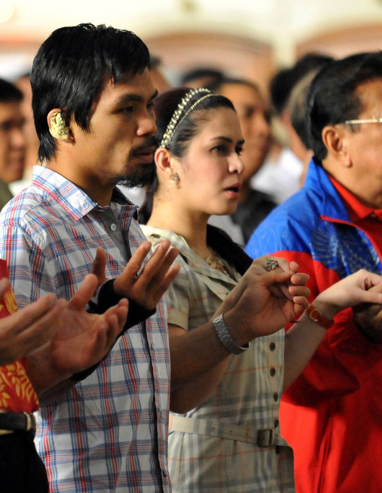 Most of Pacquiao's social media posts evoke his Christian faith and devotion to family. He is photographed with his wife Jinkee during mass in the Quiapo district of Manila on November 20, 2009. 