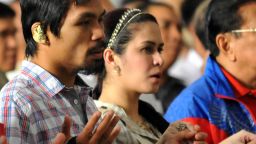Philippine boxing superstar Manny Pacquiao (L) joins hands with his wife Jinkee during mass in the Quiapo district of Manila on November 20, 2009.
