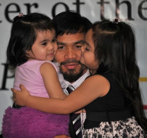 The Filipino superstar hugs his daughters Princess (R) and Queen Elizabeth during a press conference in Manila on November 20, 2010. Family snaps make up much of his Instagram feed. 