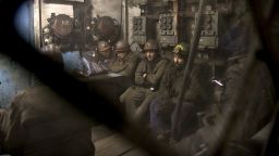 Ukrainian coal miners wait in a room before going underground to help search for the bodies.
