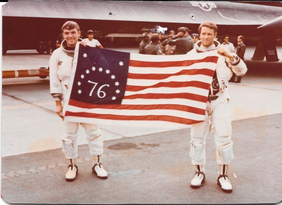 Airmen Al Joersz, left, and George Morgan hold a bicentennial American flag after breaking the world aviation speed record in 1976. 