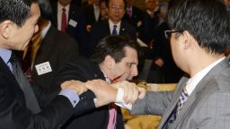 Injured U.S. Ambassador to South Korea Mark Lippert, center, is helped by other participants after he was attacked by a man at a lecture hall in Seoul, South Korea, Thursday, March 5, 2015. Lippert was in stable condition after being slashed on the face and wrist by a man wielding a 10-inch knife and screaming that the rival Koreas should be unified, South Korean police and U.S. officials said Thursday.