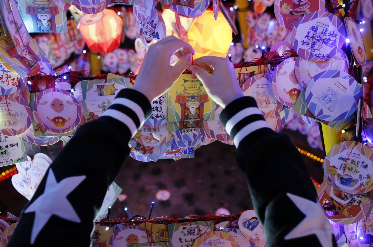 A visitor attaches a new year wish to a row of lanterns at the start of the Lantern Festival marking the end of Chinese Lunar New Year celebrations in Taipei, Taiwan, on Thursday, March 5.