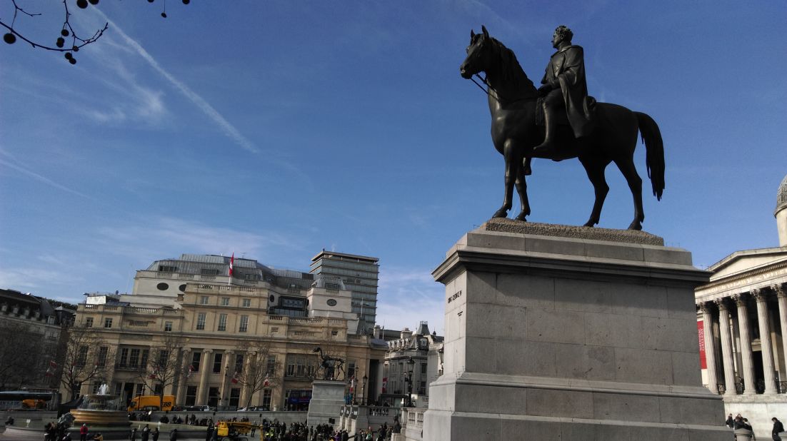 The bronze sculpture as seen from the east of Trafalgar Square with the equestrian statue of George IV in the foreground which was unveiled in 1843. 