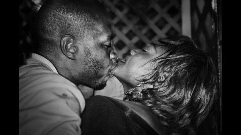 A young man kisses his girlfriend at a bar of the Ewa Bora suburbs of Lubumbashi.