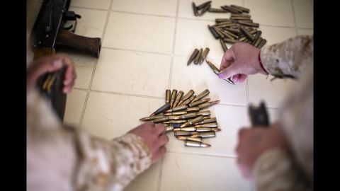 Female Peshmerga load rifle magazines.