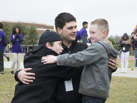 Manero's team has made electronic arms for five children and are working with three more kids including 12-year-old Wyatt Falardeau, left, who lost his right arm to amputation when he was a baby. He shares a hug with Alex and Manero at UCF. 