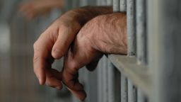 prisoner behind bars STOCK
