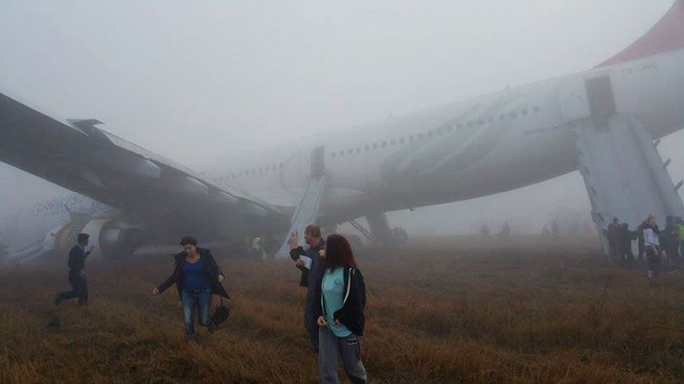 Passengers walk away from a Turkish Airlines plane after it skidded off the runway while landing in Kathmandu, Nepal, on Wednesday, March 4. No one was injured.