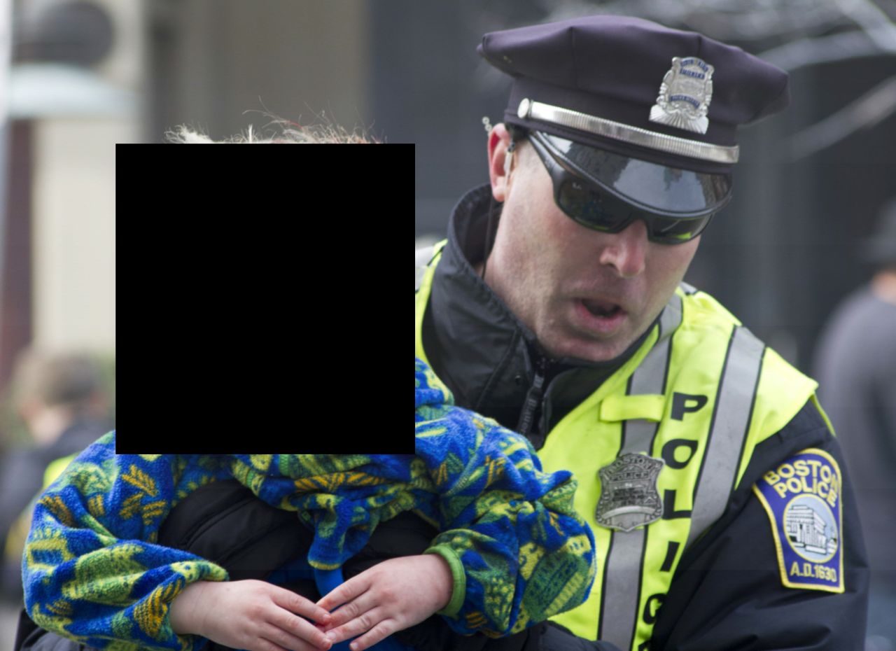 Boston police tend to a wounded child. CNN has chosen not to show the young victim's face.