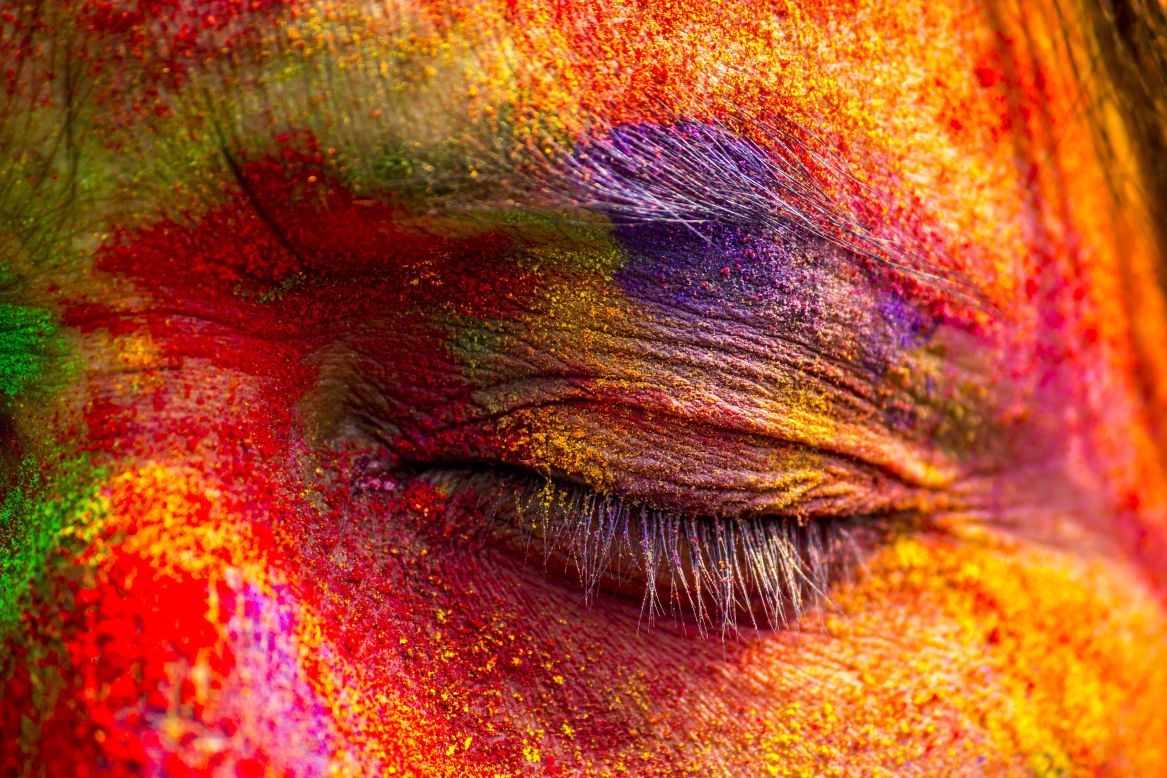 A woman's face is covered with colored powder in the Sivasagar district of northeastern India's Assam state on March 6.