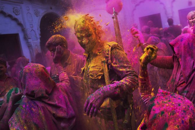 Widows throw colored powder on a police officer during celebrations at the Meera Sahabhagini Widow Ashram in Vrindavan, India, on Tuesday, March 3.